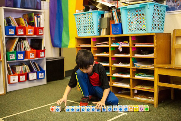 a child in the classroom playing with blocks
